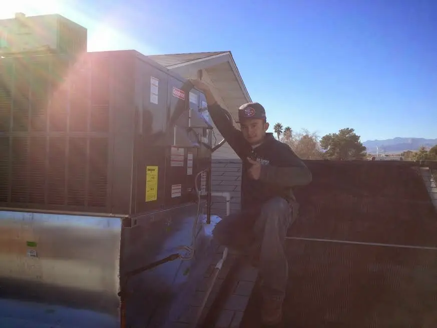 HVAC technician performing Air Duct Repair on a rooftop unit in Edina